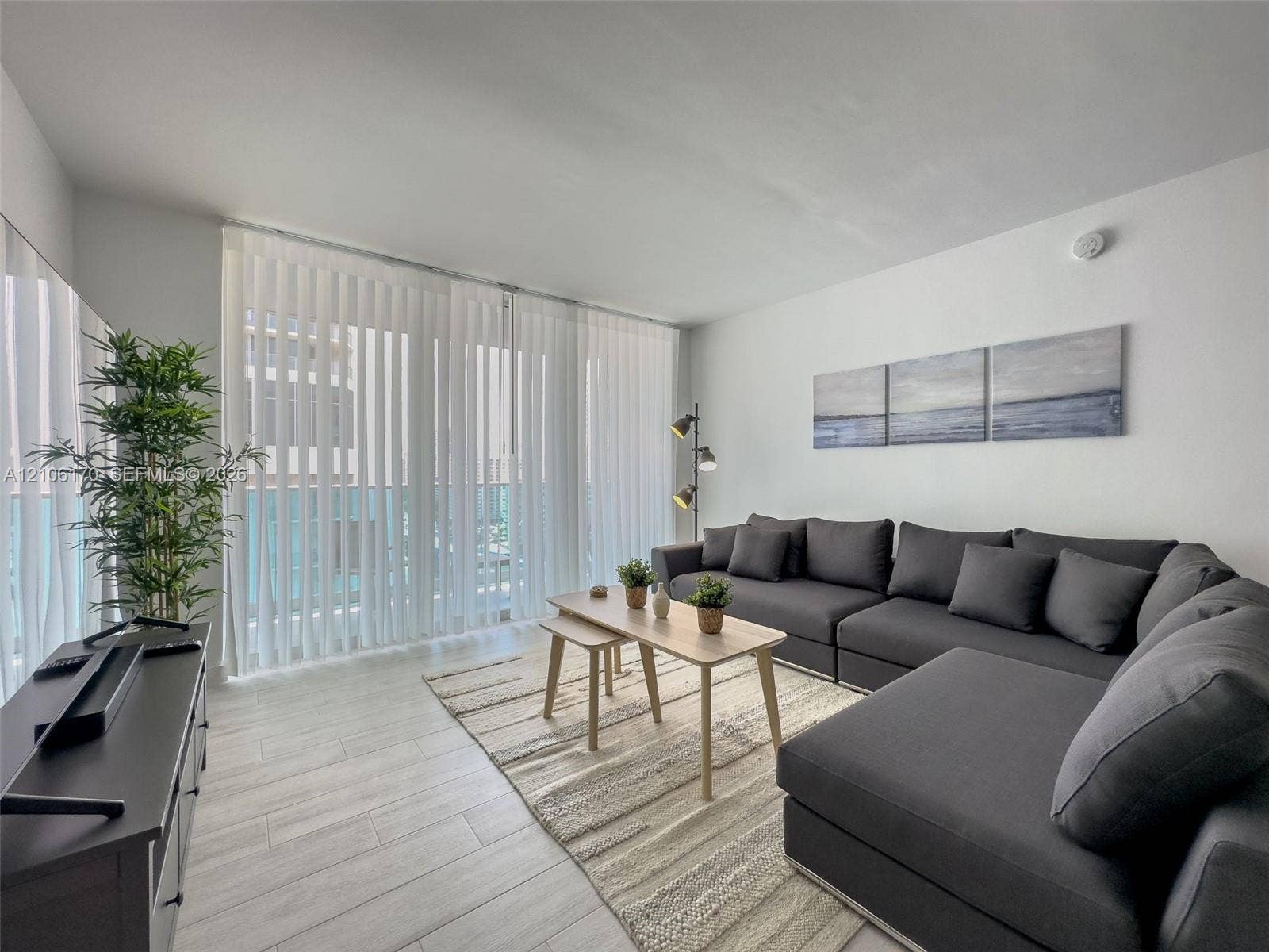 4001 S Ocean Drive, #12B, Hollywood, Hollywood, FL 33019 Living space featuring light-toned wood-finish flooring and floor-to-ceiling vertical blinds