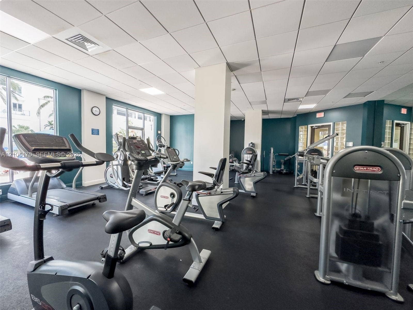 4001 S Ocean Drive, #12B, Hollywood, Hollywood, FL 33019 Fitness facility featuring rubber flooring, drop ceiling panels, floor-to-ceiling windows, and large-scale mirrored walls