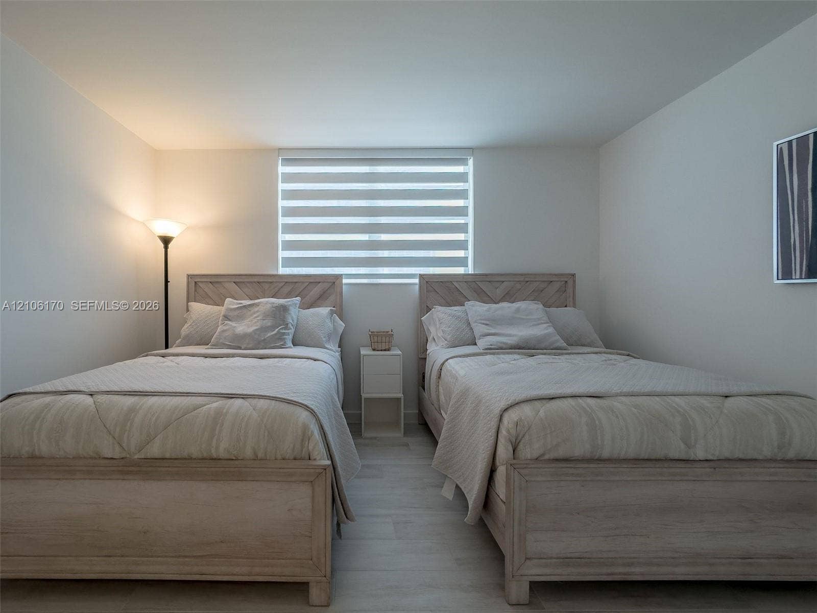 4001 S Ocean Drive, #12B, Hollywood, Hollywood, FL 33019 Neutral-toned interior space featuring light wood-finish flooring and a single window equipped with horizontal zebra shades