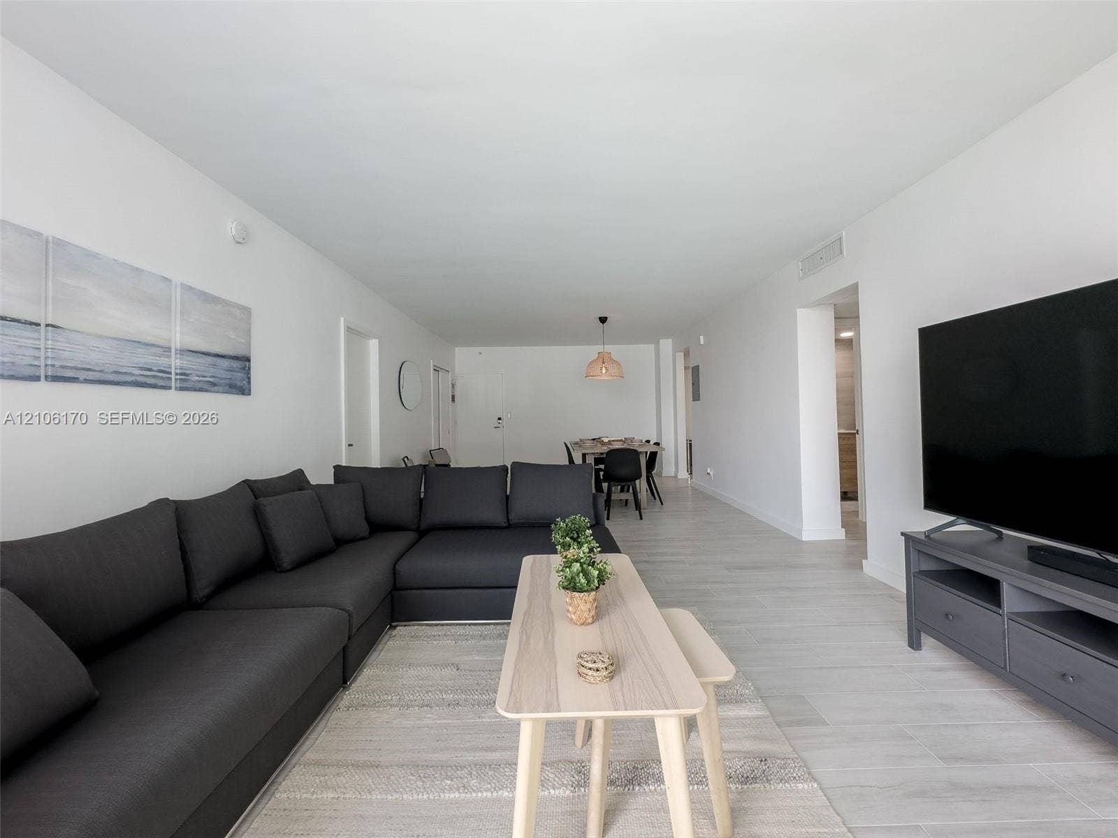 4001 S Ocean Drive, #12B, Hollywood, Hollywood, FL 33019 Open-concept interior featuring neutral white walls, light-toned wood-finish flooring, and a recessed ceiling lighting fixture