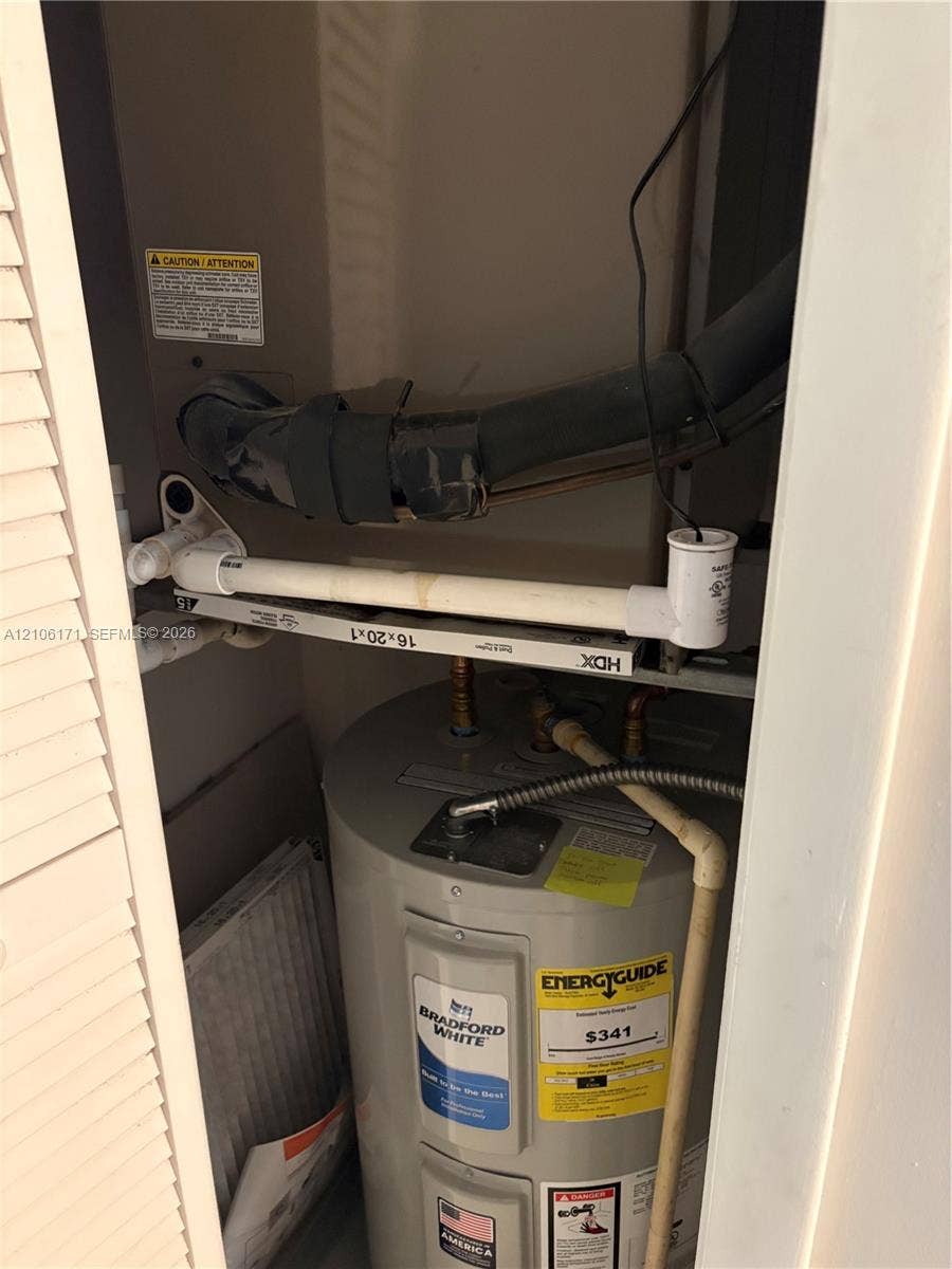 Utility closet featuring a Bradford White water heater and an HVAC air handler unit