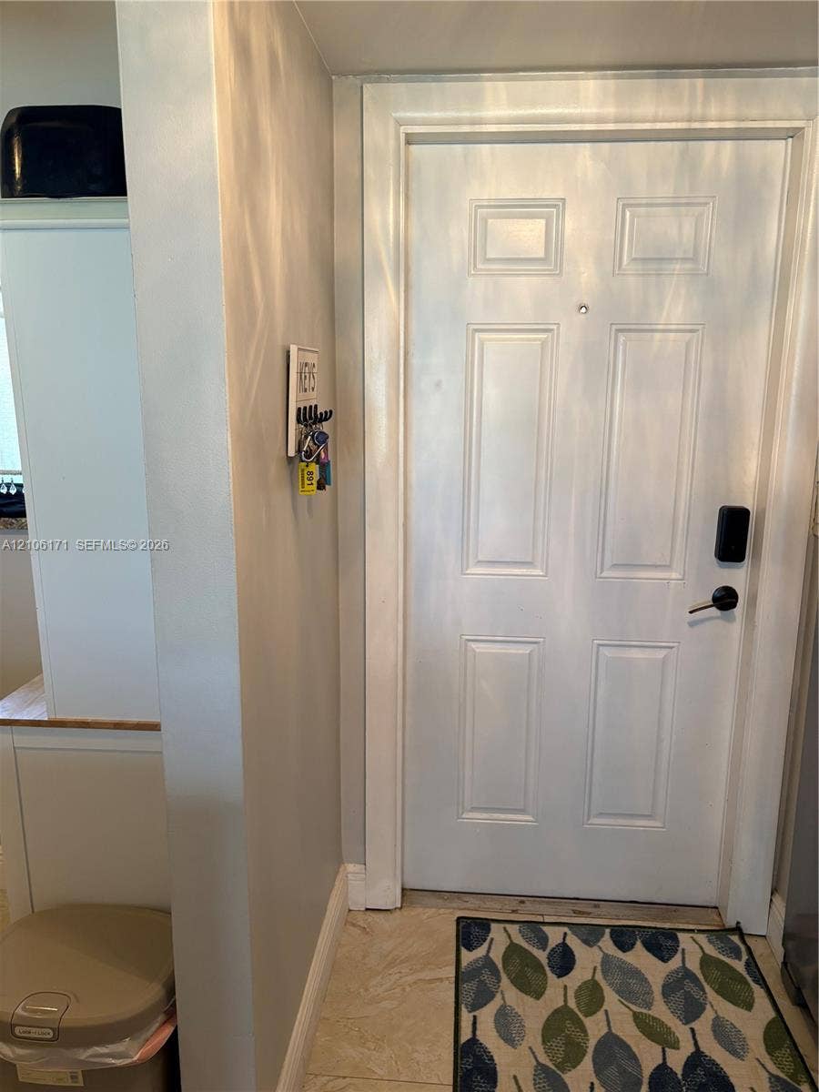 White six-panel entry door featuring a matte black handle set and digital keypad lock