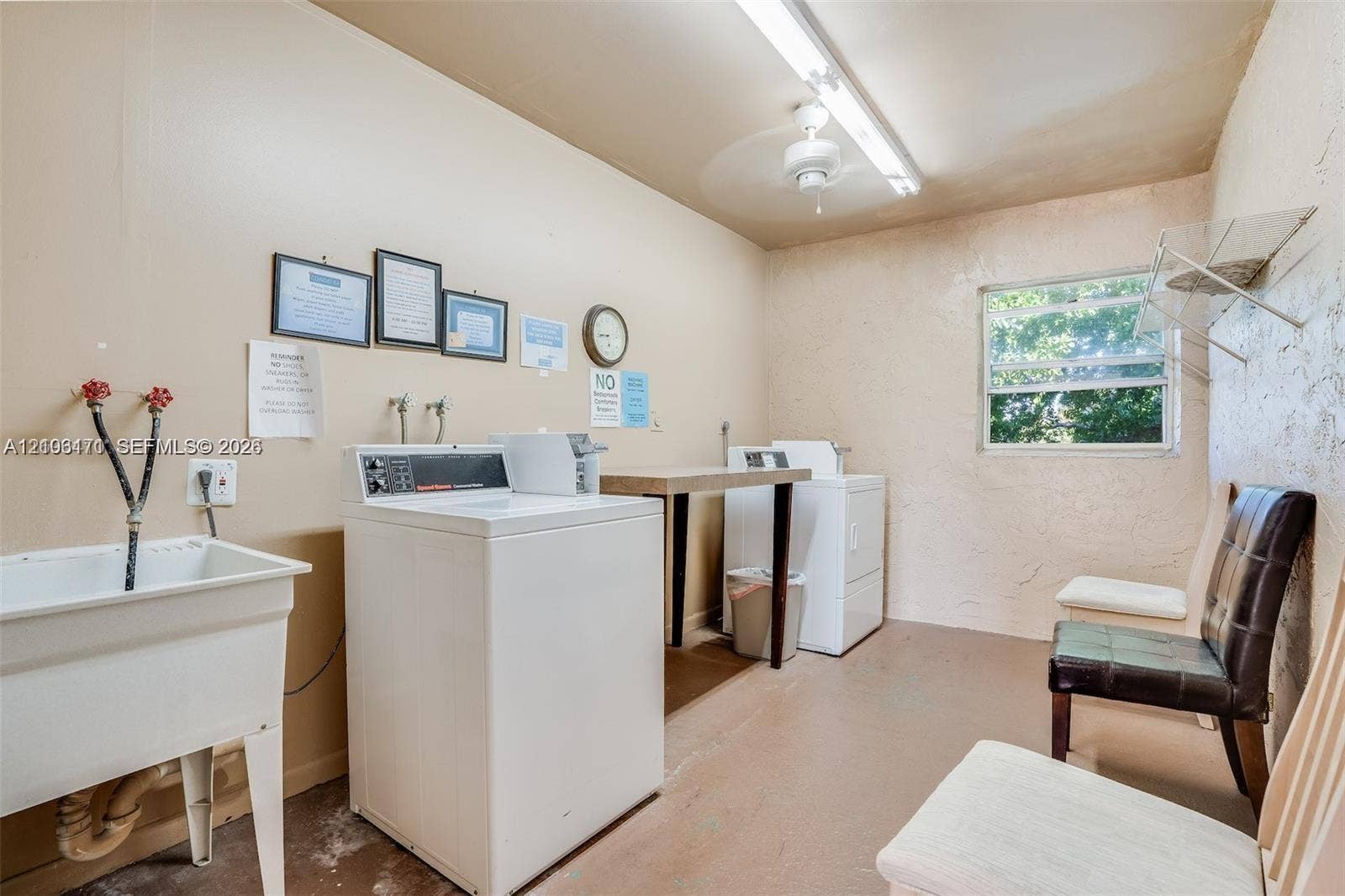Utility space featuring a deep basin laundry sink, fixed shelving, and a singular window with exterior exposure