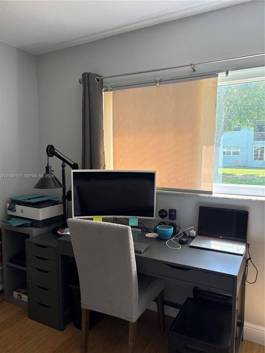 Window with light-filtering shade, metal curtain rod, and neutral wall paint