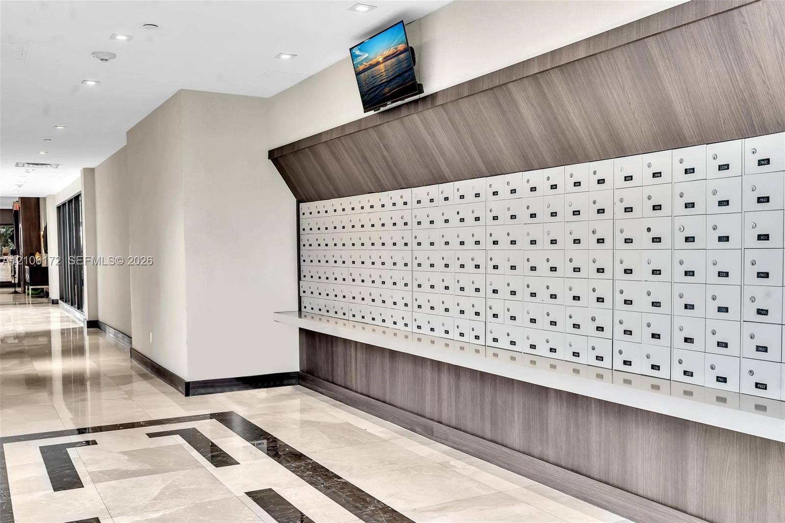 20515 E Country Club Drive, #246, Aventura, Aventura, FL 33180 Mail center featuring high-capacity integrated parcel lockers, wood-finish paneling, polished stone flooring with geometric tile inlay, and recessed ceiling lighting