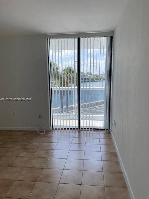 20515 E Country Club Drive, #246, Aventura, Aventura, FL 33180 Ceramic tile flooring and sliding glass doors with vertical blinds, featuring water frontage and balcony access