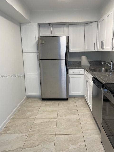 20515 E Country Club Drive, #246, Aventura, Aventura, FL 33180 Kitchen featuring white shaker-style cabinetry, stainless steel appliances, neutral stone-finish tile flooring, and contrasting stone-finish countertops