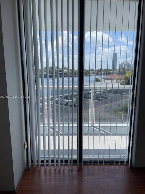 20515 E Country Club Drive, #246, Aventura, Aventura, FL 33180 Sliding glass door with vertical blinds, wood-finish flooring, and exterior balcony featuring a metal railing