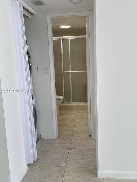20515 E Country Club Drive, #246, Aventura, Aventura, FL 33180 Stacked laundry unit housed in a bi-fold door closet, tile flooring, and a walk-in shower with a framed glass enclosure