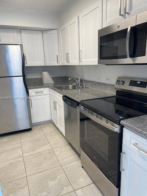 20515 E Country Club Drive, #246, Aventura, Aventura, FL 33180 Kitchen featuring white cabinetry, stone-finish countertops, stainless steel appliances, a double-basin undermount sink, and tile flooring