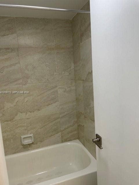 20515 E Country Club Drive, #246, Aventura, Aventura, FL 33180 Full-height wall tiling with a natural stone-patterned finish, built-in recessed soap niche, and white acrylic bathtub