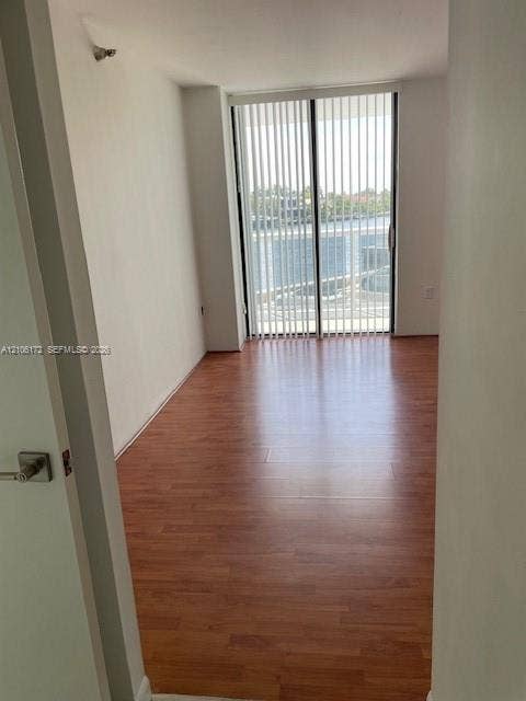 20515 E Country Club Drive, #246, Aventura, Aventura, FL 33180 Room featuring wood-finish flooring and sliding glass doors with vertical blinds