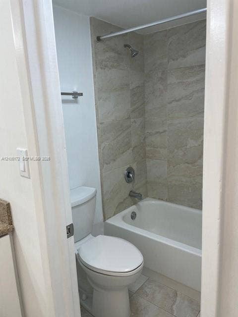 20515 E Country Club Drive, #246, Aventura, Aventura, FL 33180 Bathroom featuring a white porcelain tub with integrated shower, stone-finish tile surround, floor-mounted toilet, and wall-mounted towel bar