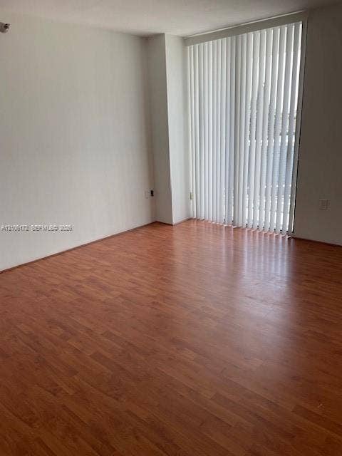20515 E Country Club Drive, #246, Aventura, Aventura, FL 33180 Wood-finish flooring and floor-to-ceiling sliding glass doors with vertical blinds