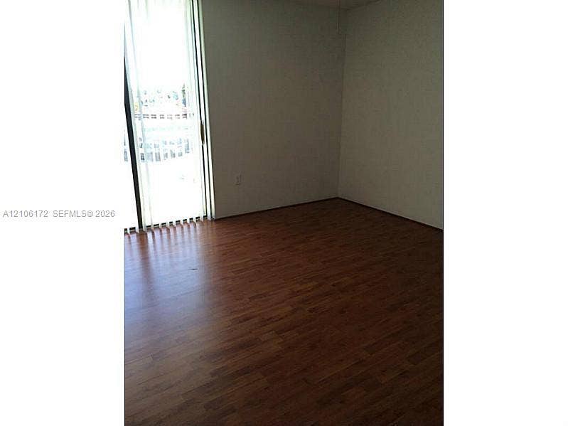 20515 E Country Club Drive, #246, Aventura, Aventura, FL 33180 Wood-finish flooring paired with vertical blinds and a sliding glass door
