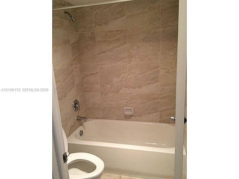 20515 E Country Club Drive, #246, Aventura, Aventura, FL 33180 Full-height shower surround with neutral-toned oversized tile, white bathtub, chrome shower fixture, and recessed soap dish