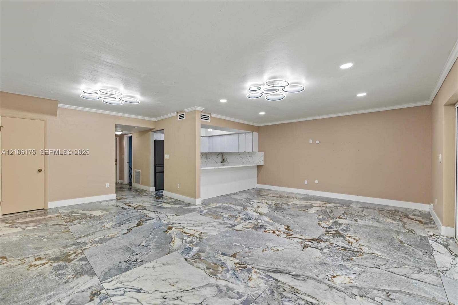 6905 W 2nd Way, #1, Hialeah, Hialeah, FL 33014 Large-format tile flooring with a variegated stone finish, dual modern multi-ring flush-mount lighting, recessed ceiling lights, kitchen peninsula with matching stone-finish backsplash, and flat-panel cabinetry
