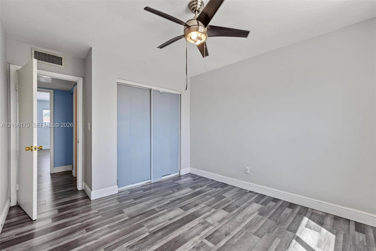 6905 W 2nd Way, #1, Hialeah, Hialeah, FL 33014 Neutral wall finishes, wood-finish flooring, brushed metal ceiling fan with integrated lighting, and dual-panel sliding closet doors