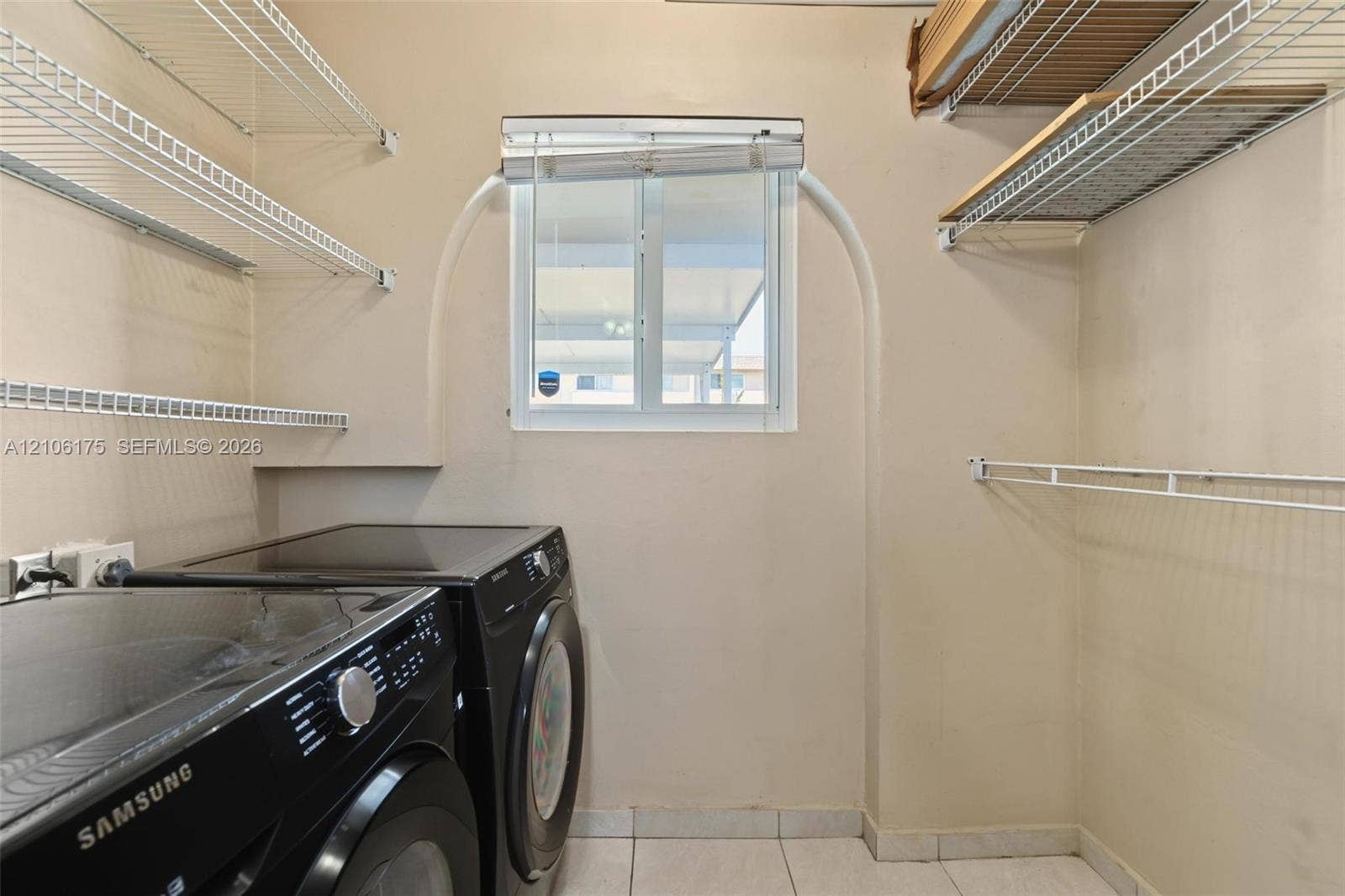 6905 W 2nd Way, #1, Hialeah, Hialeah, FL 33014 Laundry area featuring tile flooring, arched window recess, and built-in wire shelving