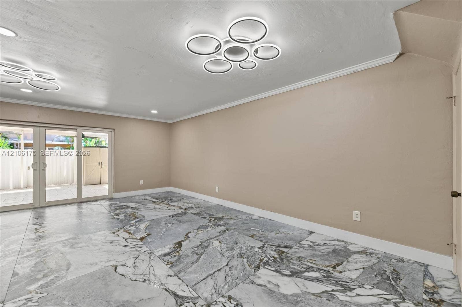 6905 W 2nd Way, #1, Hialeah, Hialeah, FL 33014 Large-format stone-look tile flooring featuring high-contrast veining, dual contemporary circular LED flush-mount lighting fixtures, and a sliding glass door with a multi-pane grid