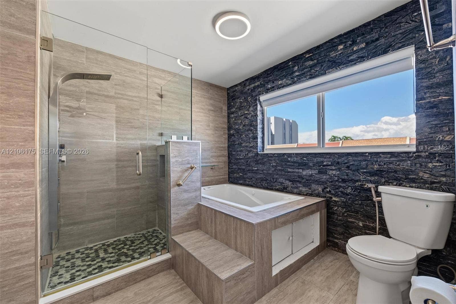 6905 W 2nd Way, #1, Hialeah, Hialeah, FL 33014 Walk-in shower with a glass enclosure, built-in soaking tub featuring a stepped surround, textured slate-style wall accents, and neutral tile flooring