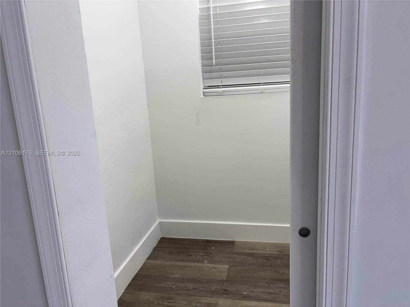 214 NW 46th Avenue, #214, Miami, Miami, FL 33126 Enclosed area featuring wood-finish flooring, white walls, and a window with horizontal blinds
