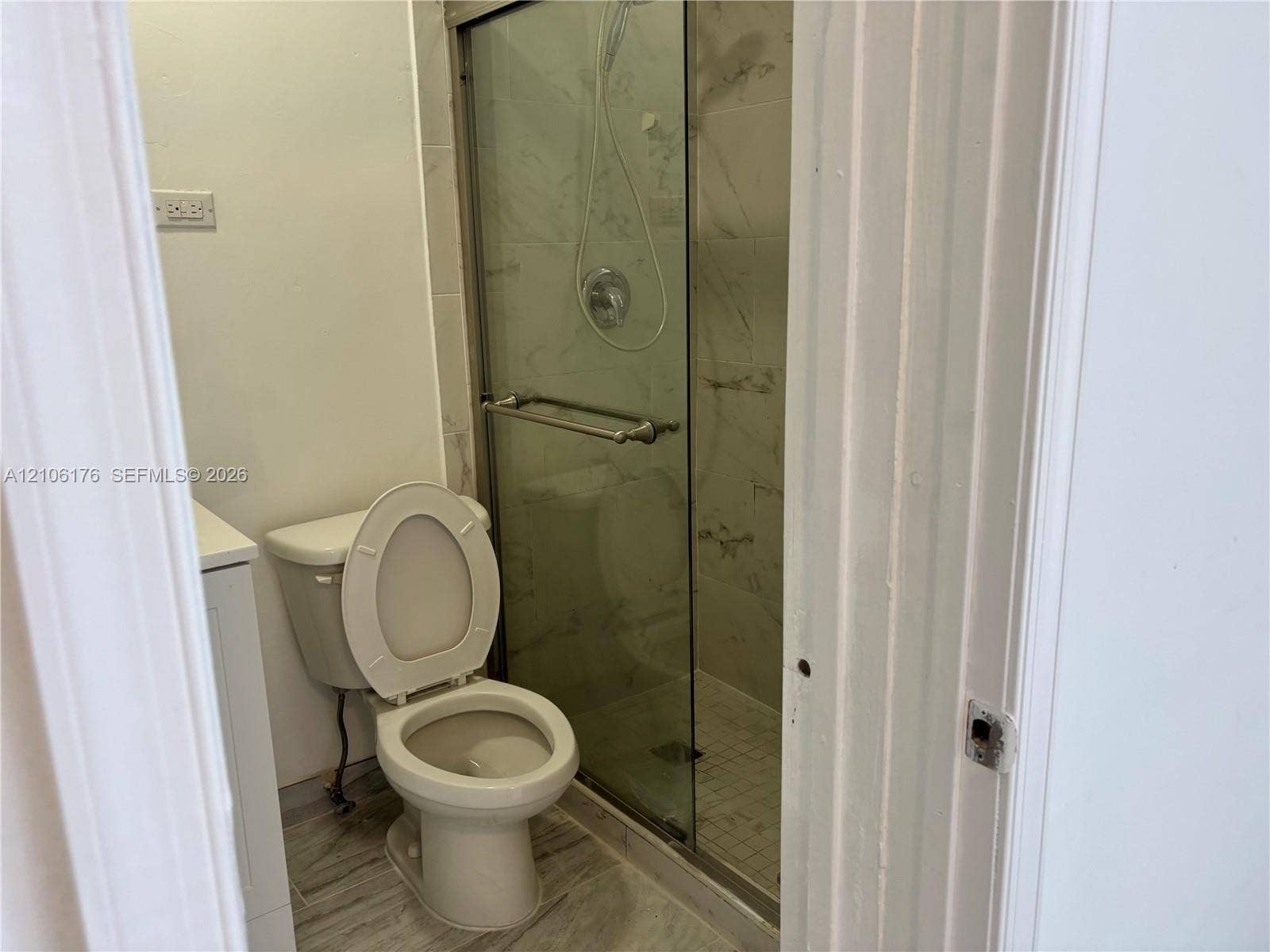 214 NW 46th Avenue, #214, Miami, Miami, FL 33126 Walk-in shower with sliding glass doors, stone-patterned tile wall surround, and wood-finish flooring