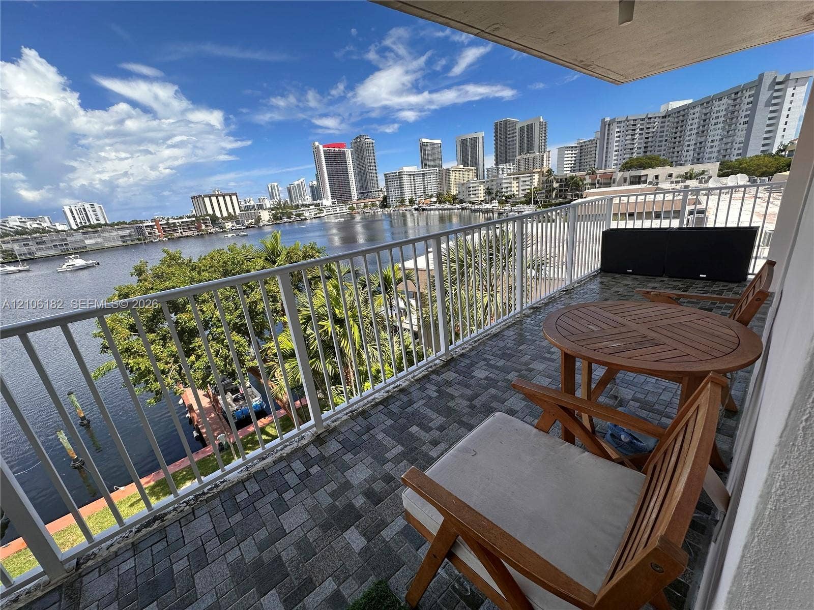 400 Golden Isles Drive, #40, Hallandale Beach, Hallandale Beach, FL 33009 Covered balcony featuring stone-paver flooring and white metal railing with panoramic water and city skyline backdrop