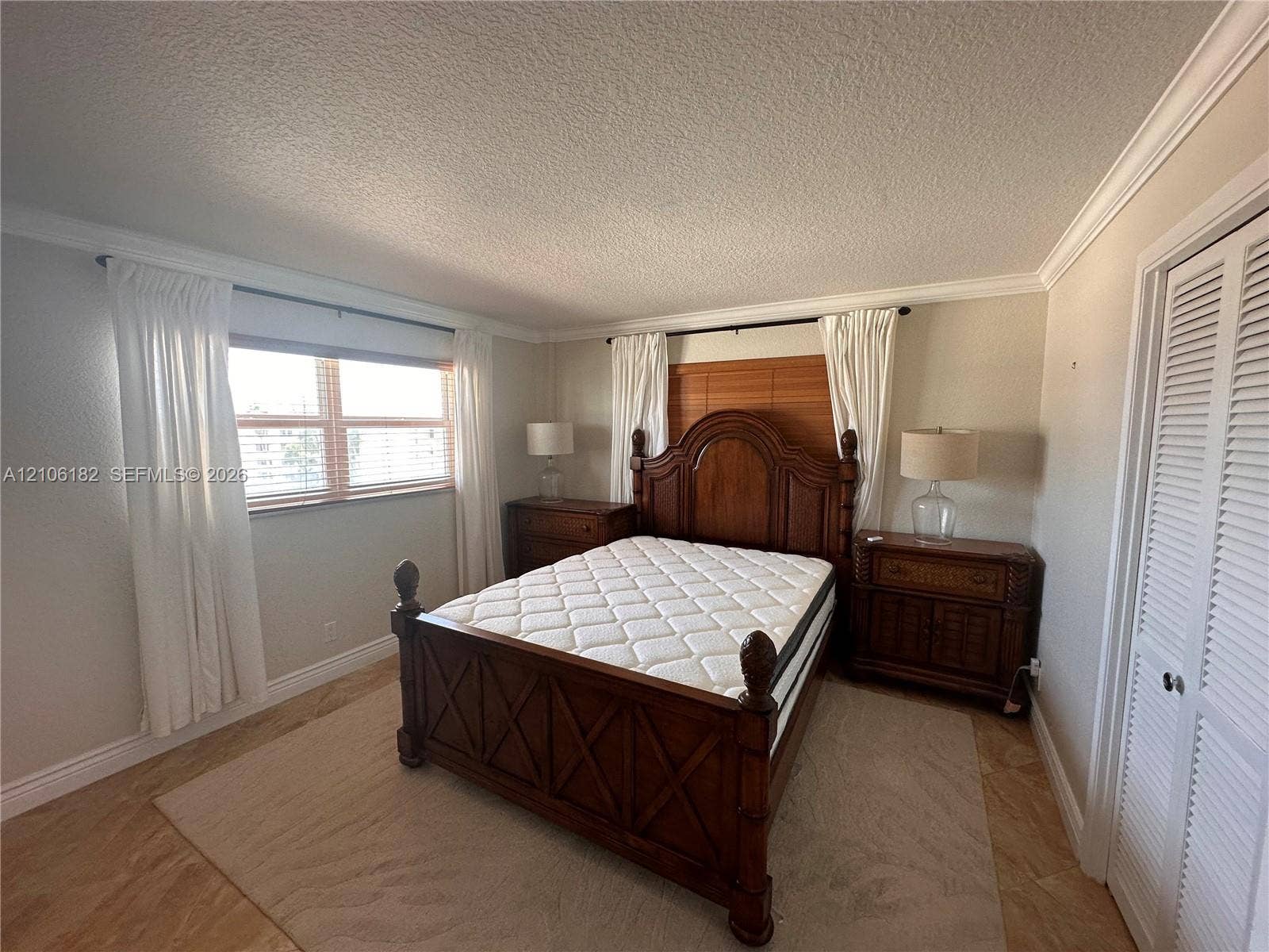400 Golden Isles Drive, #40, Hallandale Beach, Hallandale Beach, FL 33009 Room featuring wood-finish flooring, crown molding, and louvered bi-fold closet doors