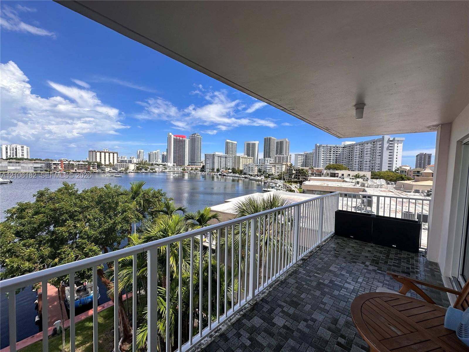 400 Golden Isles Drive, #40, Hallandale Beach, Hallandale Beach, FL 33009 Covered balcony featuring white vertical railing, textured flooring, and water and skyline scenery