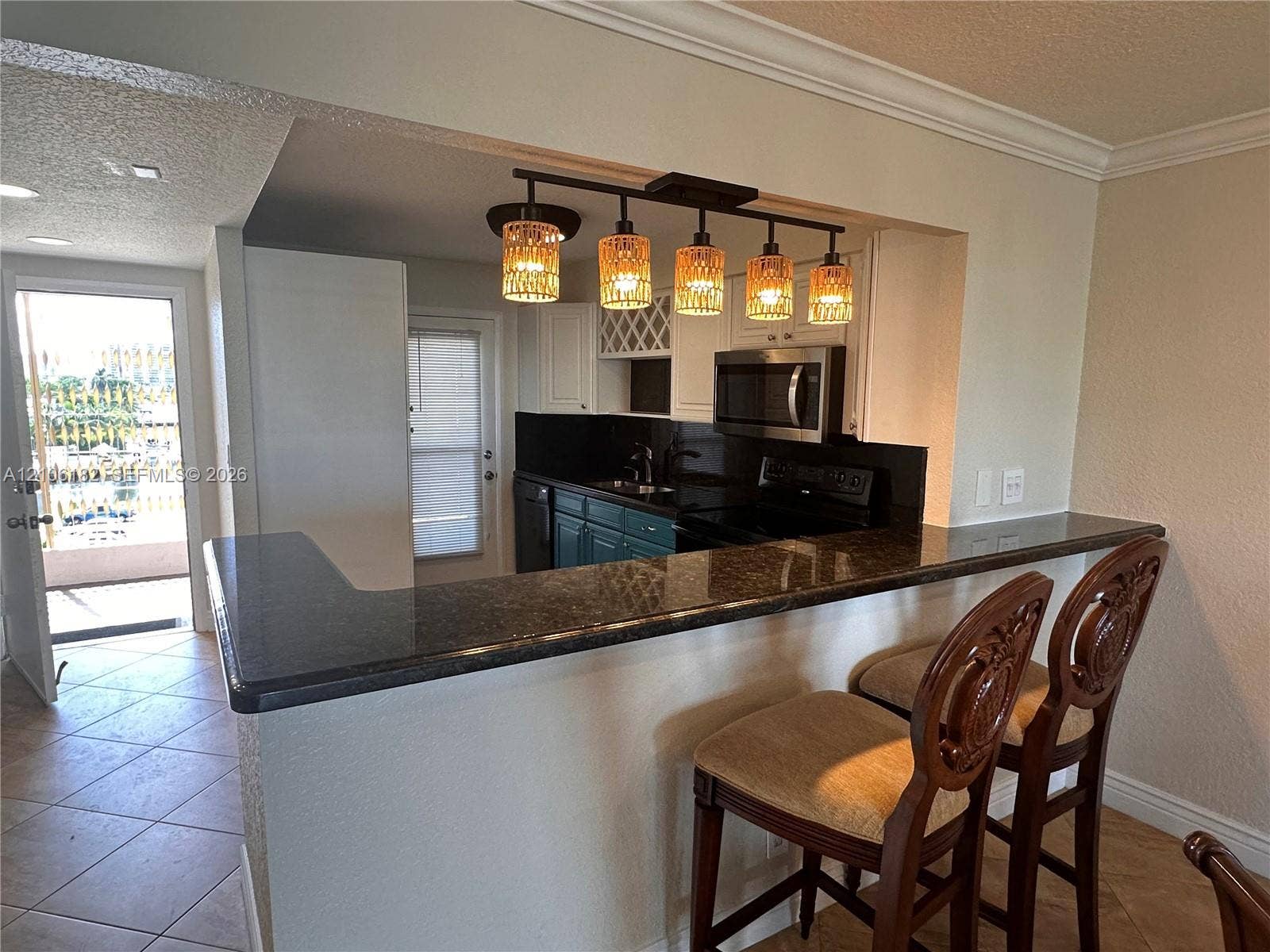 400 Golden Isles Drive, #40, Hallandale Beach, Hallandale Beach, FL 33009 Kitchen featuring dark stone countertops, a raised breakfast bar, built-in wine rack, and a five-light pendant fixture