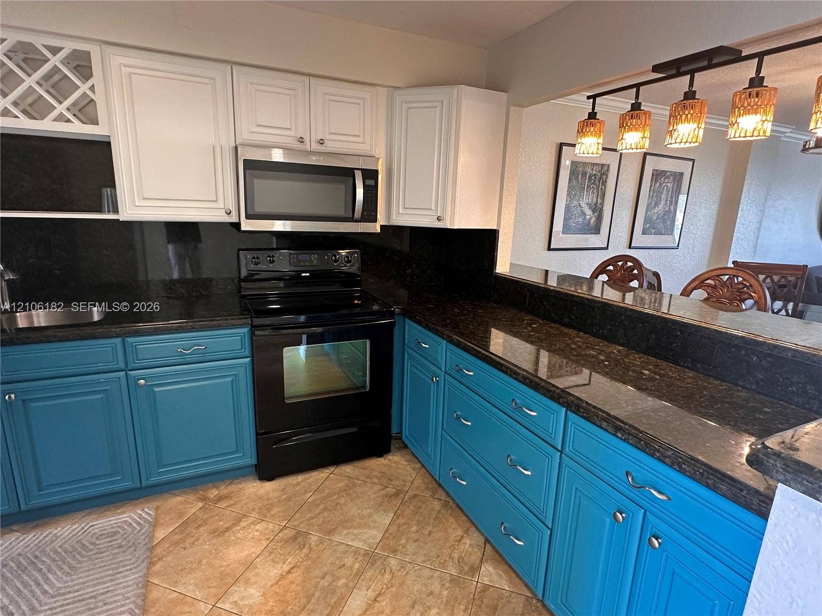 400 Golden Isles Drive, #40, Hallandale Beach, Hallandale Beach, FL 33009 Kitchen featuring dual-toned cabinetry, dark stone-finish countertops, stainless steel appliances, built-in wine storage, and a tiered breakfast bar with multi-pendant overhead lighting