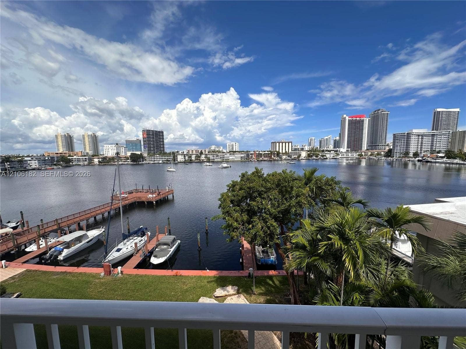 400 Golden Isles Drive, #40, Hallandale Beach, Hallandale Beach, FL 33009 Waterfront setting featuring a private dock, boat slips, mature landscaping, and an expansive cityscape backdrop
