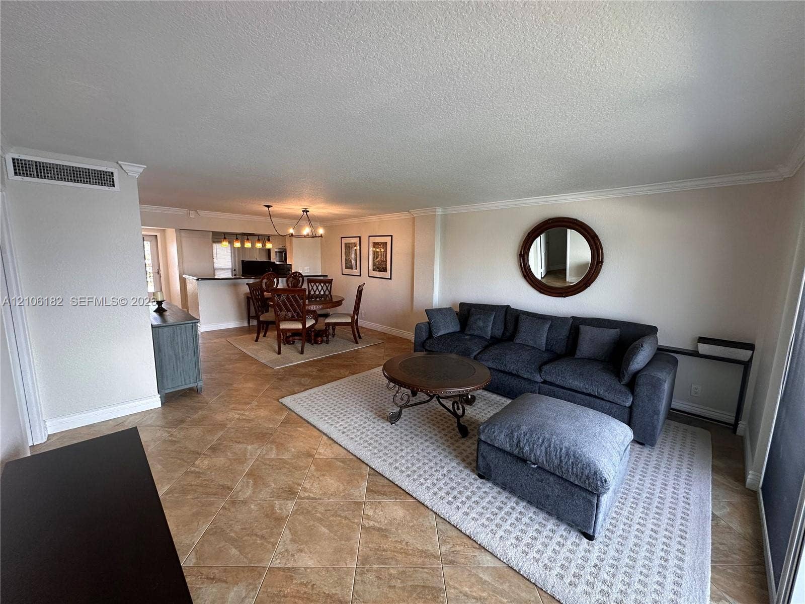 400 Golden Isles Drive, #40, Hallandale Beach, Hallandale Beach, FL 33009 Open-concept interior featuring large-format diagonal floor tiling, crown molding, and a multi-pendant light fixture over the dining area