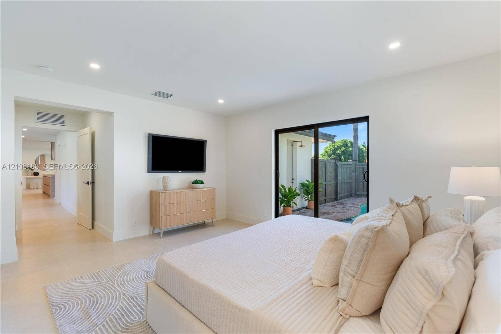 Neutral interior featuring recessed lighting, large-format tile flooring, and a glass sliding door providing exterior access