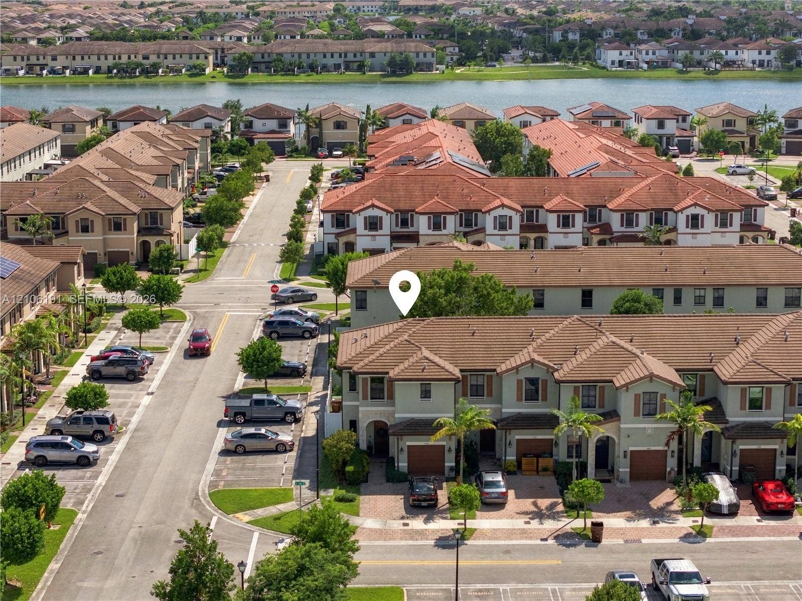 3402 W 105th Street, Hialeah, FL 33018 Multi-level townhome featuring a clay tile roof, stucco exterior, integrated garage, and brick-paver driveway
