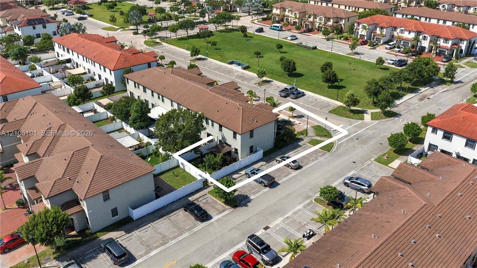 3402 W 105th Street, Hialeah, FL 33018 Aerial perspective of a multi-story residence featuring a tile roof, enclosed fenced yard, and dedicated surface parking