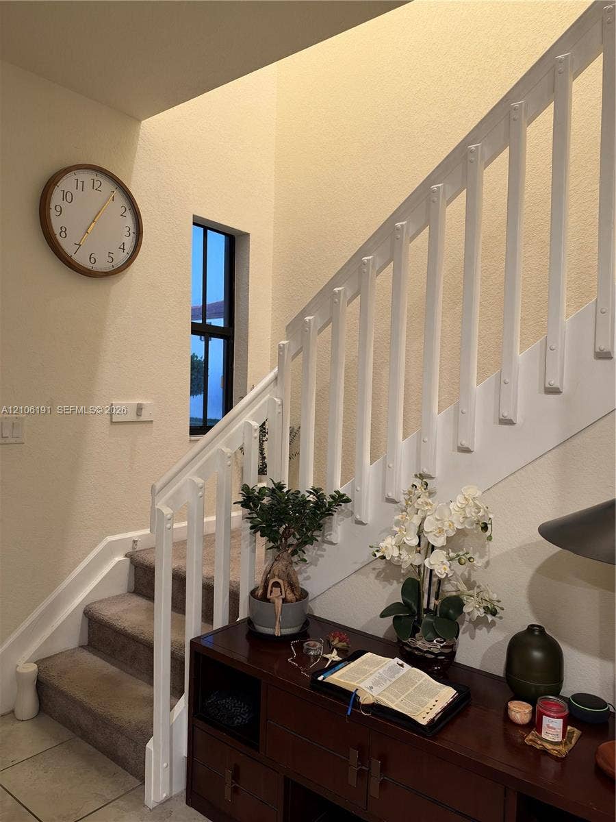3402 W 105th Street, Hialeah, FL 33018 Staircase featuring white balusters, carpeted treads, and a narrow vertical window
