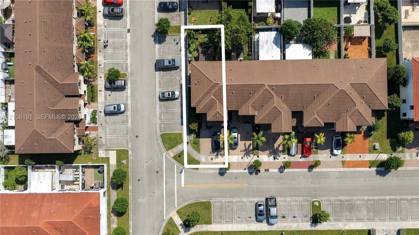 3402 W 105th Street, Hialeah, FL 33018 Aerial perspective highlighting a multi-unit property featuring a shingle roof, concrete driveway, attached parking, and established landscaping