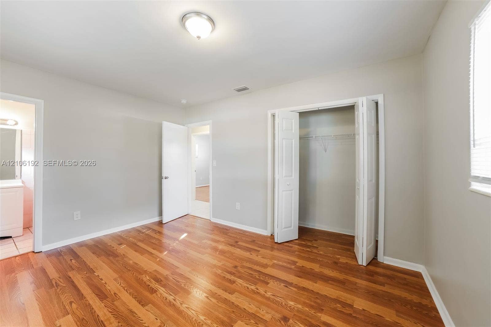 19100 NW 12th Avenue, Miami Gardens, Miami Gardens, FL 33169 Interior space featuring wood-finish flooring, neutral wall paint, and a built-in closet with double-panel doors