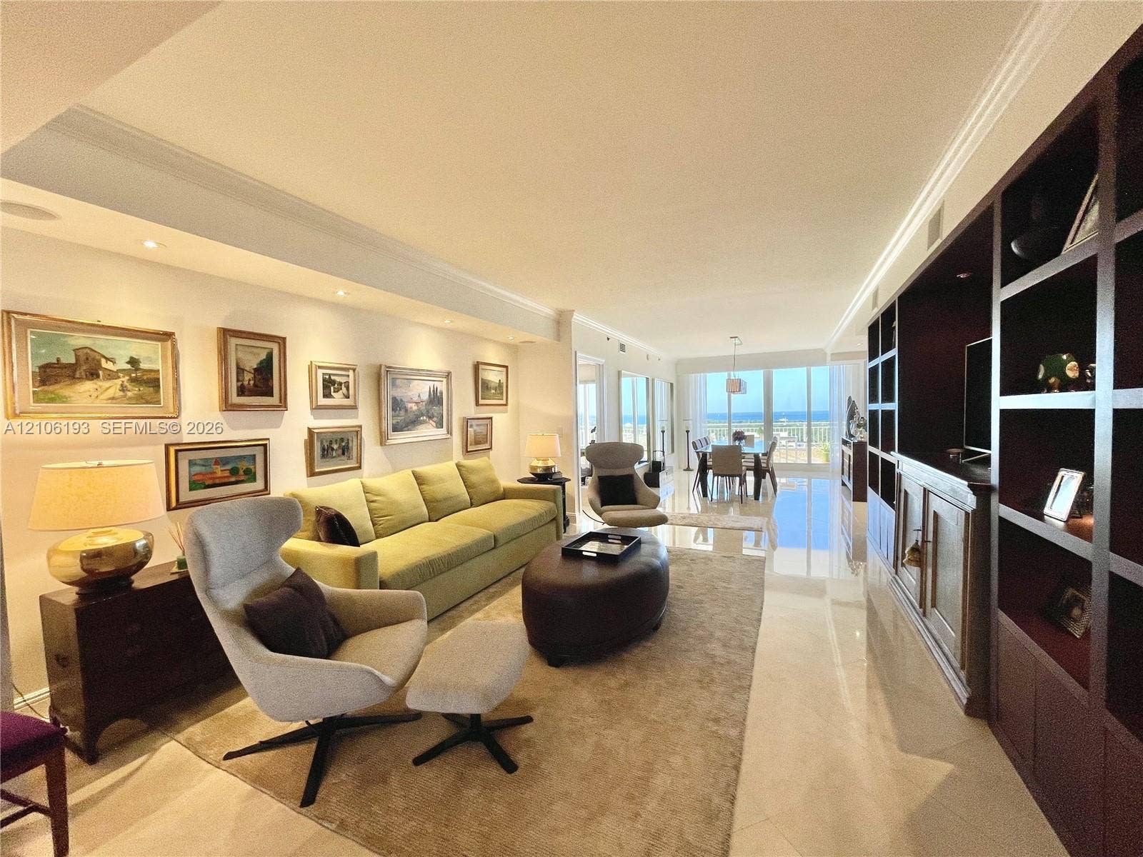 799 Crandon Boulevard, #1203, Key Biscayne, Key Biscayne, FL 33149 Open-concept living space featuring large-format polished stone flooring, custom floor-to-ceiling dark wood built-in cabinetry, recessed perimeter lighting, and expansive glass sliding doors