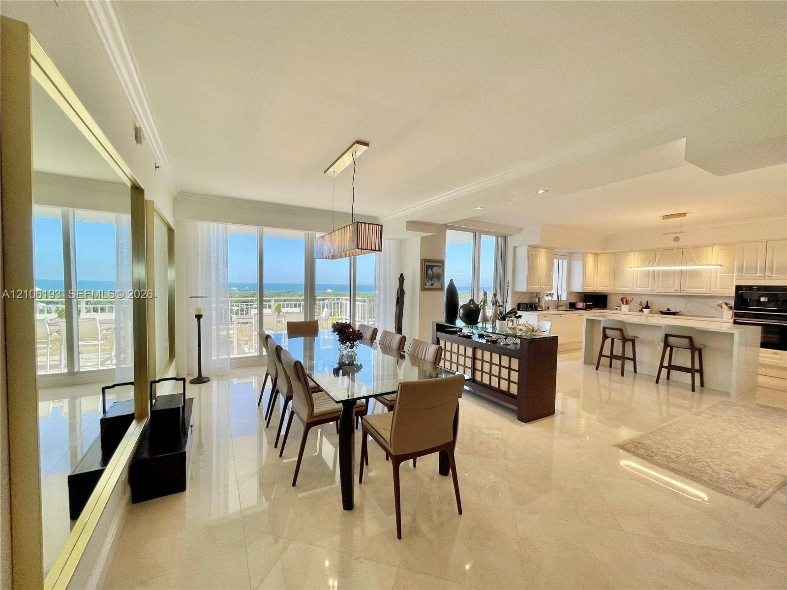 799 Crandon Boulevard, #1203, Key Biscayne, Key Biscayne, FL 33149 Open-concept living space featuring polished tile flooring, floor-to-ceiling glass sliding doors, custom white cabinetry, a built-in kitchen island with stone-finish countertops, and recessed lighting