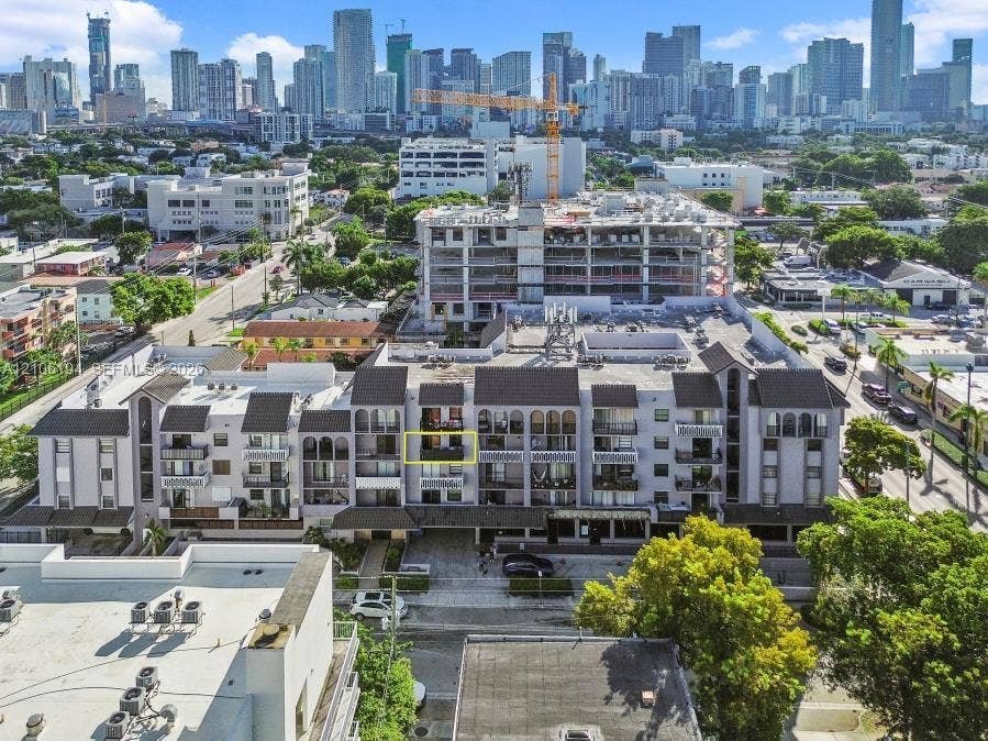 777 SW 9th Avenue, #408, Miami, FL 33130 Multi-story residential building featuring arched architectural accents, a private balcony, a flat roofline, and proximity to an urban skyline