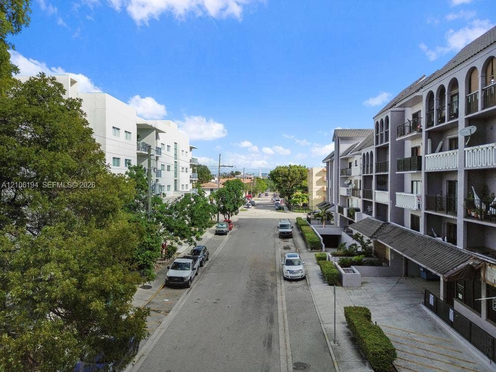 777 SW 9th Avenue, #408, Miami, FL 33130 Multi-story residential building exterior featuring arched architectural detailing, private balconies, and covered parking access