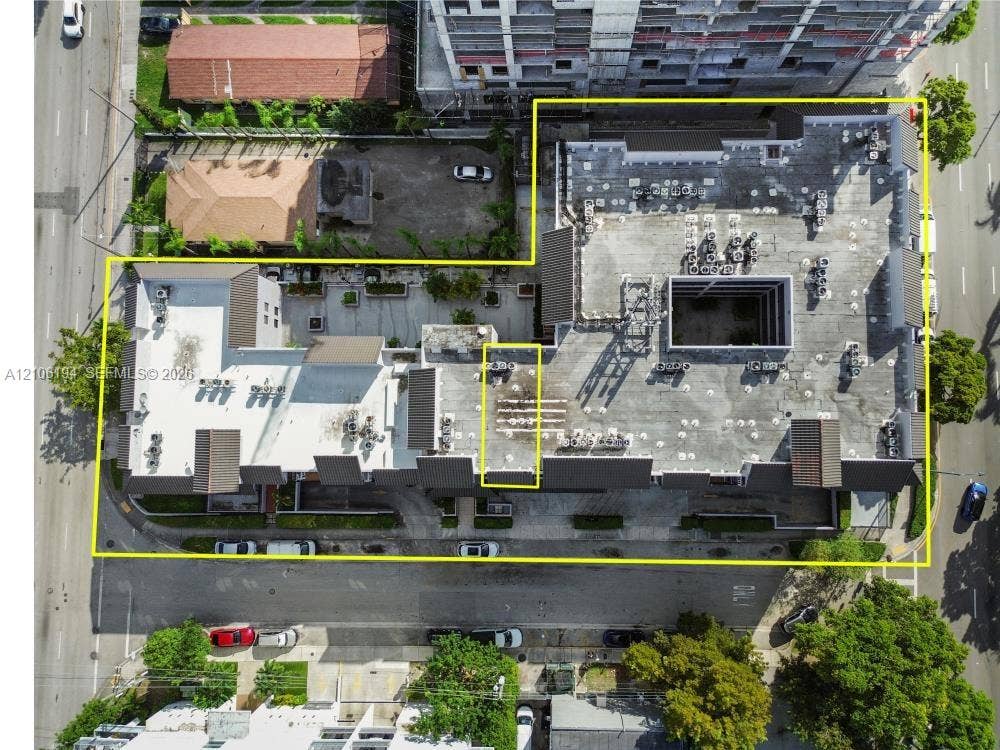 777 SW 9th Avenue, #408, Miami, FL 33130 Aerial perspective of the property featuring a multi-level flat roof structure with dark shingled accents and an internal courtyard