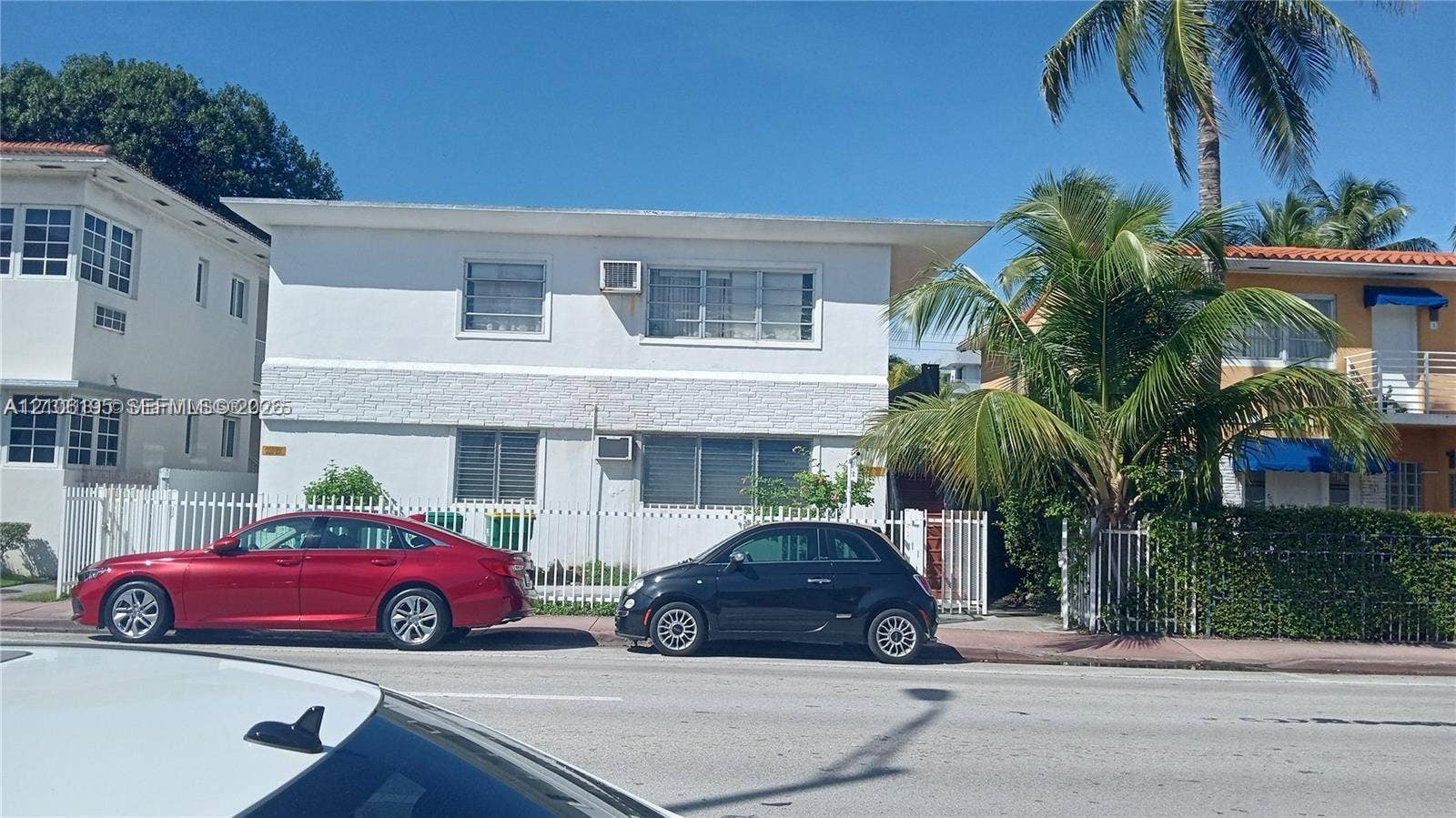 8132 Harding Avenue, #11, Miami Beach, Miami Beach, FL 33141 Two-story exterior featuring a white stucco facade, horizontal slider windows, and a perimeter fence