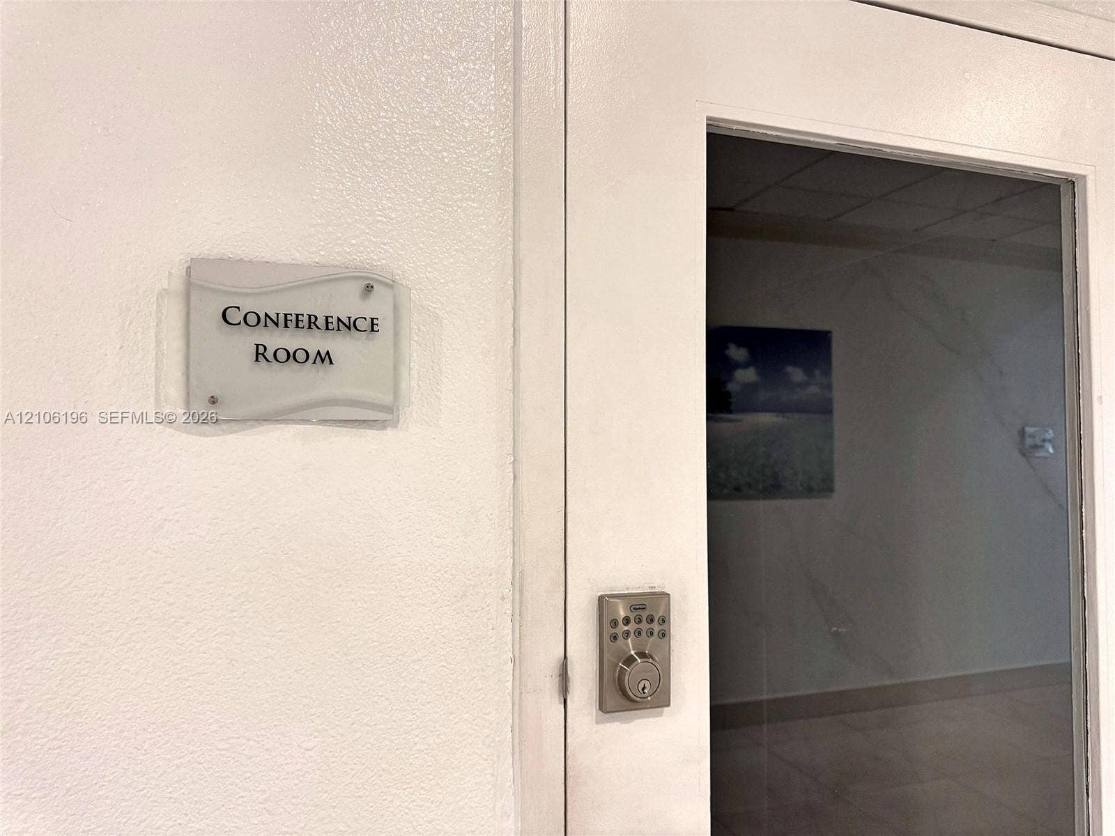 Dedicated conference room featuring a glass-panel door, secure electronic keypad lock, and wall-mounted signage