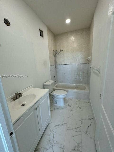 17660 NW 73rd Avenue, #202-3, Hialeah, Hialeah, FL 33015 Bathroom featuring a vanity with an integrated sink, polished faucet, white shaker-style cabinetry, and a combination tub and shower with light-toned tiled surrounds and veined stone-patterned floor tile