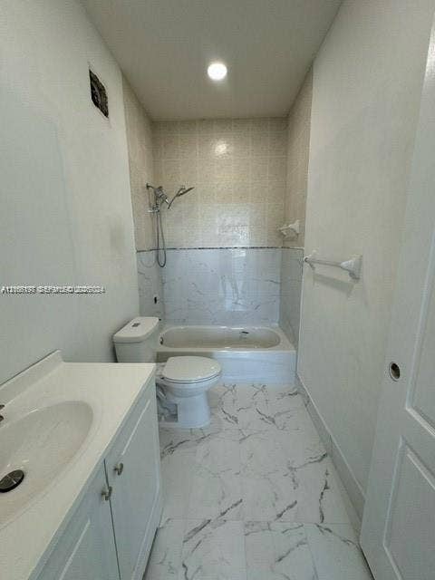 17660 NW 73rd Avenue, #202-3, Hialeah, Hialeah, FL 33015 Bathroom featuring a white vanity cabinet, composite countertop with integrated sink, porcelain tile flooring with veining, and a tiled tub-shower surround with a handheld shower fixture