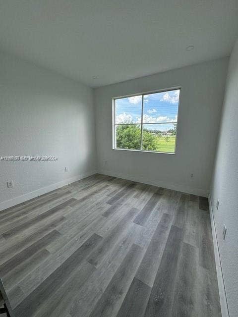 17660 NW 73rd Avenue, #202-3, Hialeah, Hialeah, FL 33015 Neutral-toned interior space featuring wood-finish flooring, recessed lighting, and a large window with exterior greenery
